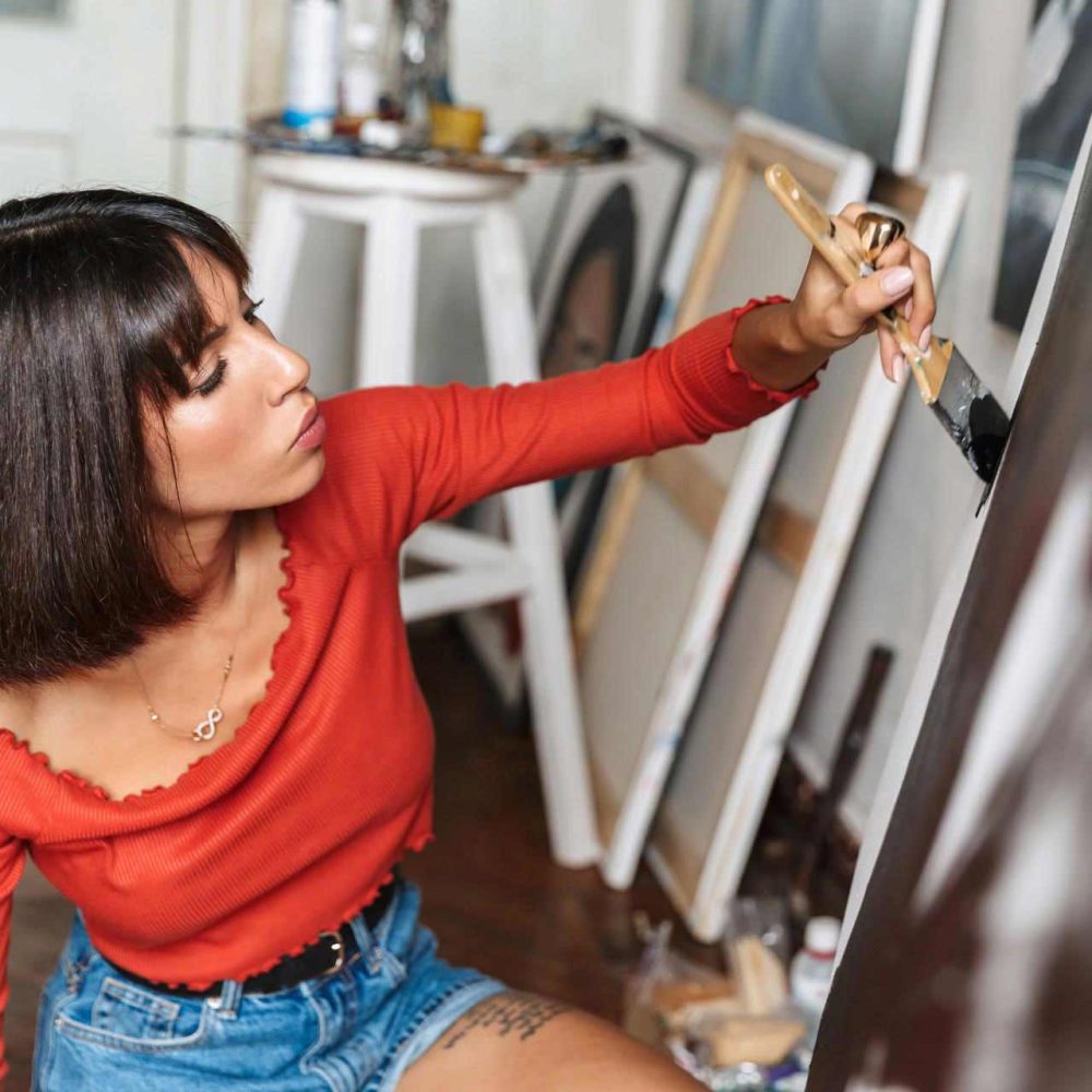 portrait-of-young-woman-using-painting-tools-while-V66ZSVM.jpg